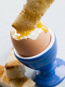 Toasted Soldier being Dipped into a Soft Boiled Egg Yolk