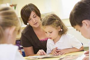 Student in class with teacher reading (selective focus)