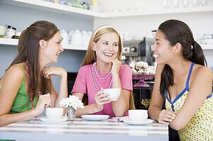 Three young woman sitting at a table and drinking tea