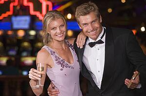 Couple in casino with cigar and champagne smiling (selective focus)