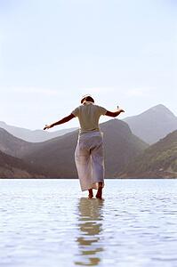 Woman outdoors walking on water in scenic location