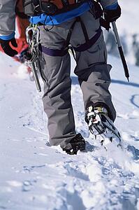 Two mountain climbers walking in snow (selective focus)