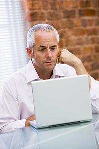 Businessman sitting in office on laptop