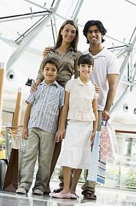 Family standing in mall smiling (selective focus)