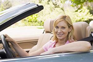 Woman in convertible car smiling