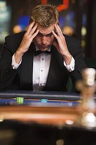 Man in casino playing roulette and losing (selective focus)