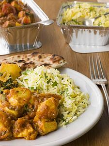 Plate Of Indian Take Away- Chicken Bhoona, Sag Aloo, Pilau Rice And Naan Bread