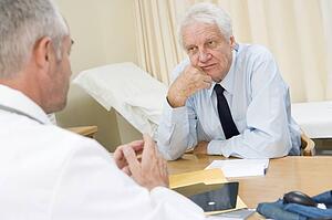 Man in doctor's office frowning