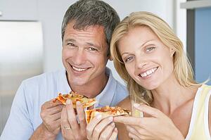 Husband And Wife Eating Pizza