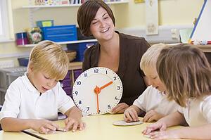 Students in class learning how to tell time (selective focus)
