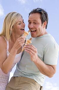 Couple outdoors eating ice cream and smiling