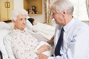 Senior Man Sitting With His Wife In Hospital