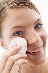 Woman removing makeup and smiling