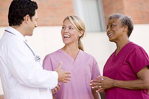 Doctor And Nurses Standing Outside A Hospital