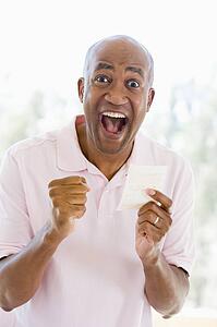 Man with winning lottery ticket excited and smiling