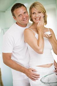 Couple in bathroom with face cream smiling