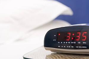 Empty bedroom with focus on alarm clock