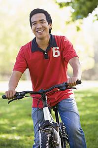 Man outdoors on bike smiling