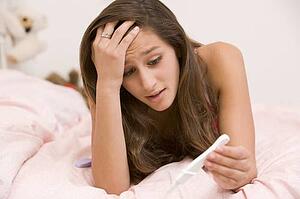 Teenage Girl Lying On Her Bed With A Pregnancy Test