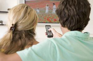 Couple in living room watching television