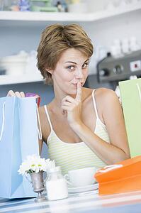 Young woman sitting at a table taking a break from shopping and drinking tea