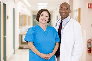 A Doctor And Nurse Standing In A Hospital Corridor