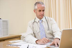 Doctor using laptop in doctor's office