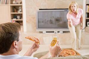 Wife Telling Husband Off For Drinking Beer And Eating Pizza