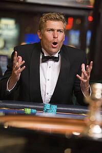 Man in casino playing roulette and losing (selective focus)