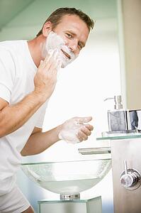 Man in bathroom shaving
