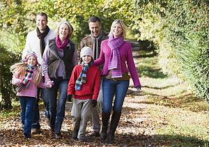 Family walking outdoors in park and smiling
