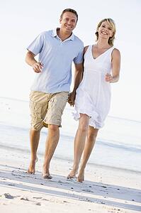 Couple at the beach holding hands and smiling