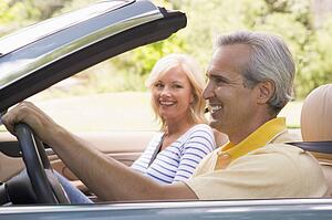 Couple in convertible car smiling