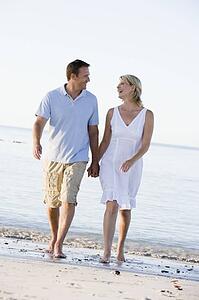 Couple at the beach holding hands and smiling