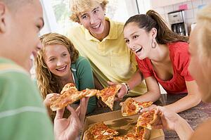 Group Of Teenagers Eating Pizza 