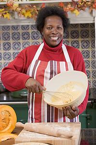 Woman in kitchen making Halloween treats and smiling