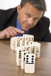 Businessman Playing With Dominos