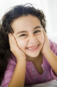 Young girl in living room smiling (high key/selective focus)