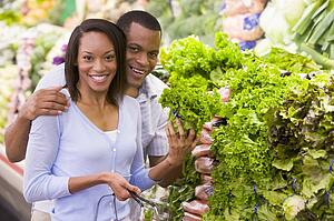 Young couple shopping for lettuce at a grocery store
