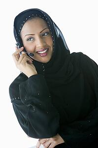 Woman indoors wearing headset and smiling (high key/selective focus)