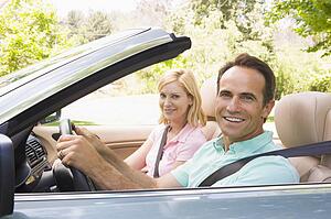 Couple in convertible car smiling