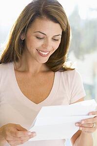 Woman reading letter smiling