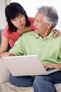Couple in living room with laptop smiling
