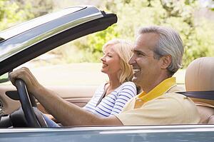 Couple in convertible car smiling