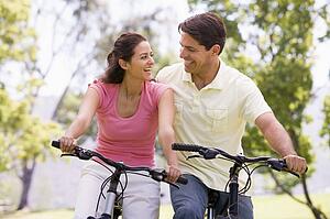 Couple on bikes outdoors smiling
