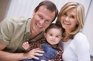 Couple indoors with baby smiling