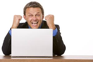 Businessman Cheering At Laptop 