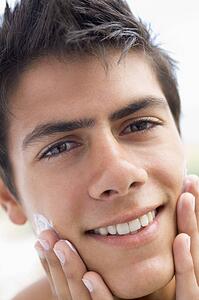 Man applying shaving cream smiling