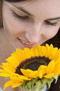 Woman holding and smelling a sunflower