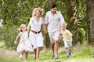 Family running on path holding hands smiling